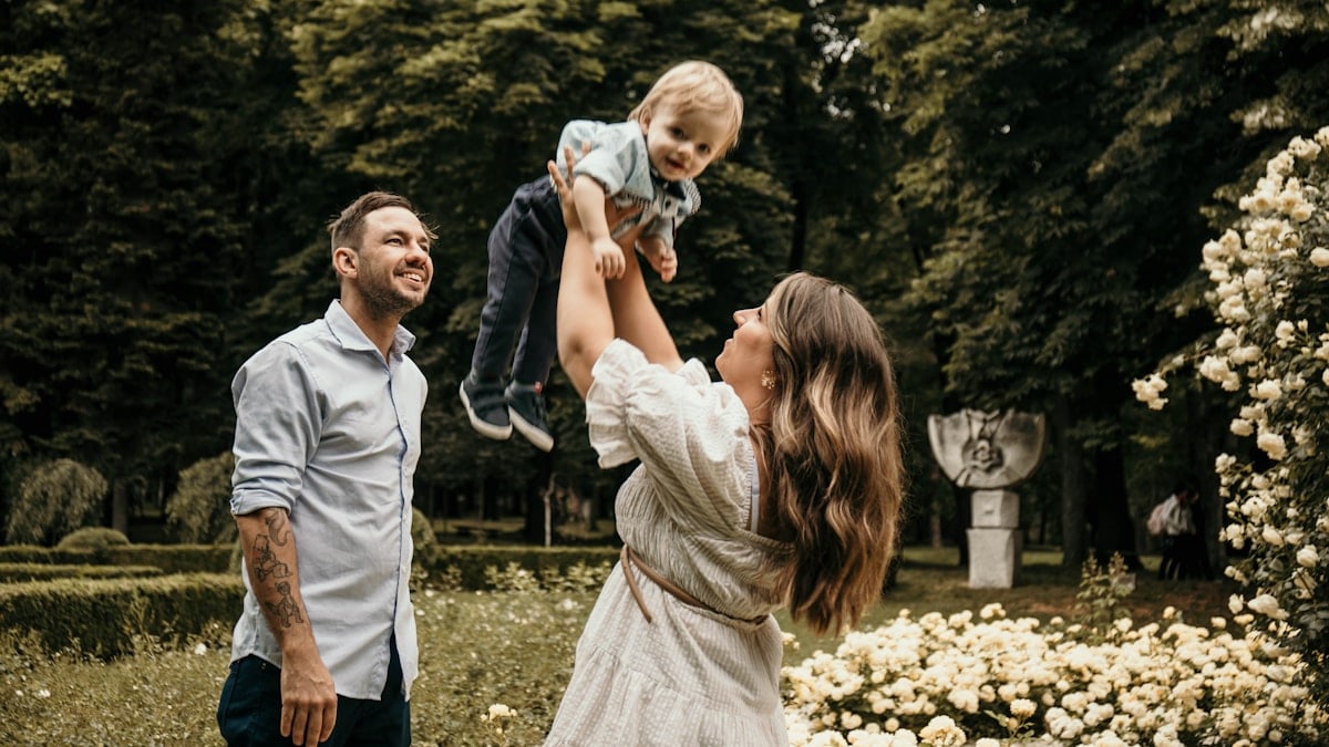 a woman holding a baby up in the air